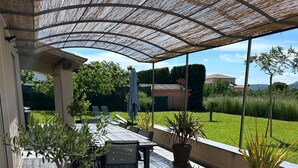 An outdoor patio area with a covered seating arrangement, potted plants, and a view of the surrounding landscape. - 🌿Very luminous villa near Uzès - peace & quiet 🌿 (Cavillargues)