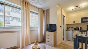 A modern apartment with a kitchen, dining area, and a TV. - Charming Suite Center of Paris Le Marais (Paris)