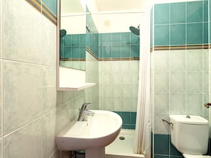 Un baño con lavamanos, inodoro y ducha.