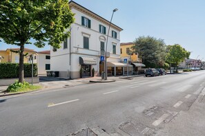 Straßenansicht eines weißen Gebäudes mit Café und Bäckerei im Erdgeschoss.