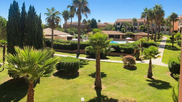 Ein Resort mit Pool, Palmen und einem gepflegten Rasen.