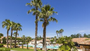 Ein Resort mit Palmen, einem Swimmingpool und einem gepflasterten Weg.