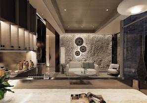 A modern living room with a sofa, armchairs, a coffee table, and a stone wall with circular decor.