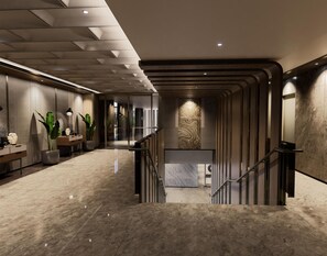 A modern hotel lobby with a marble floor, a reception desk, potted plants, and a staircase. - Hilton Padalarang Bandung (Padalarang)