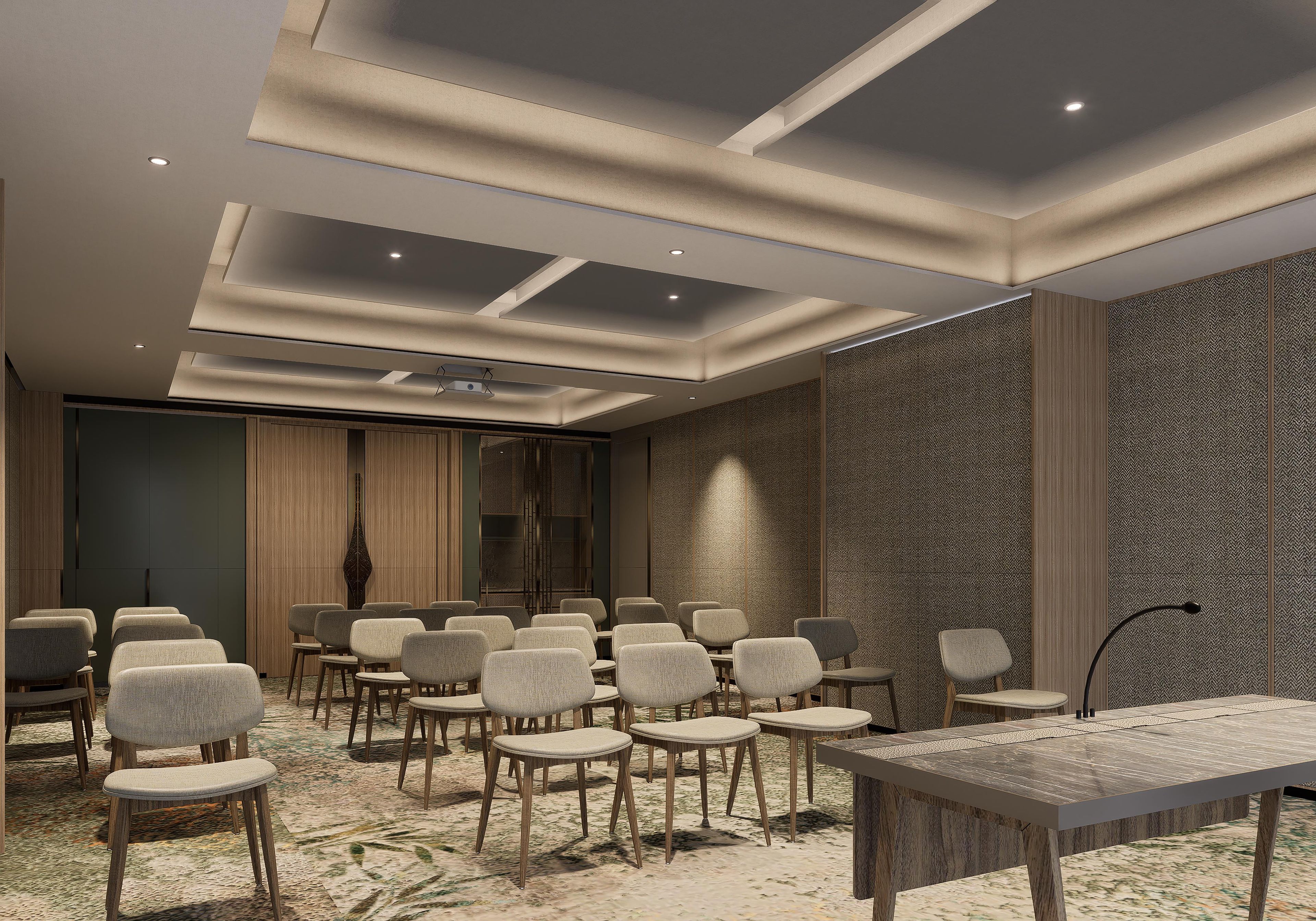 A conference room with a long table and multiple chairs, recessed ceiling lights, and patterned wall panels.