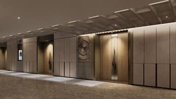 A modern hallway with a patterned wall, a digital display, and a door with a unique handle.
