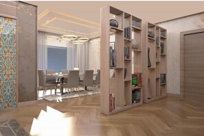 Un interior moderno con una zona de comedor, una estantería y un papel pintado decorativo.