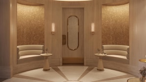 Un hall d’entrée moderne et circulaire, doté d’une porte centrale, de deux petites tables de chaque côté et d’un grand miroir mural.
