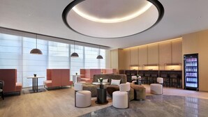 Ein stilvoller Lounge-Bereich mit Sitzgelegenheiten, einer Kaffeemaschine und einem Getränkeautomaten.