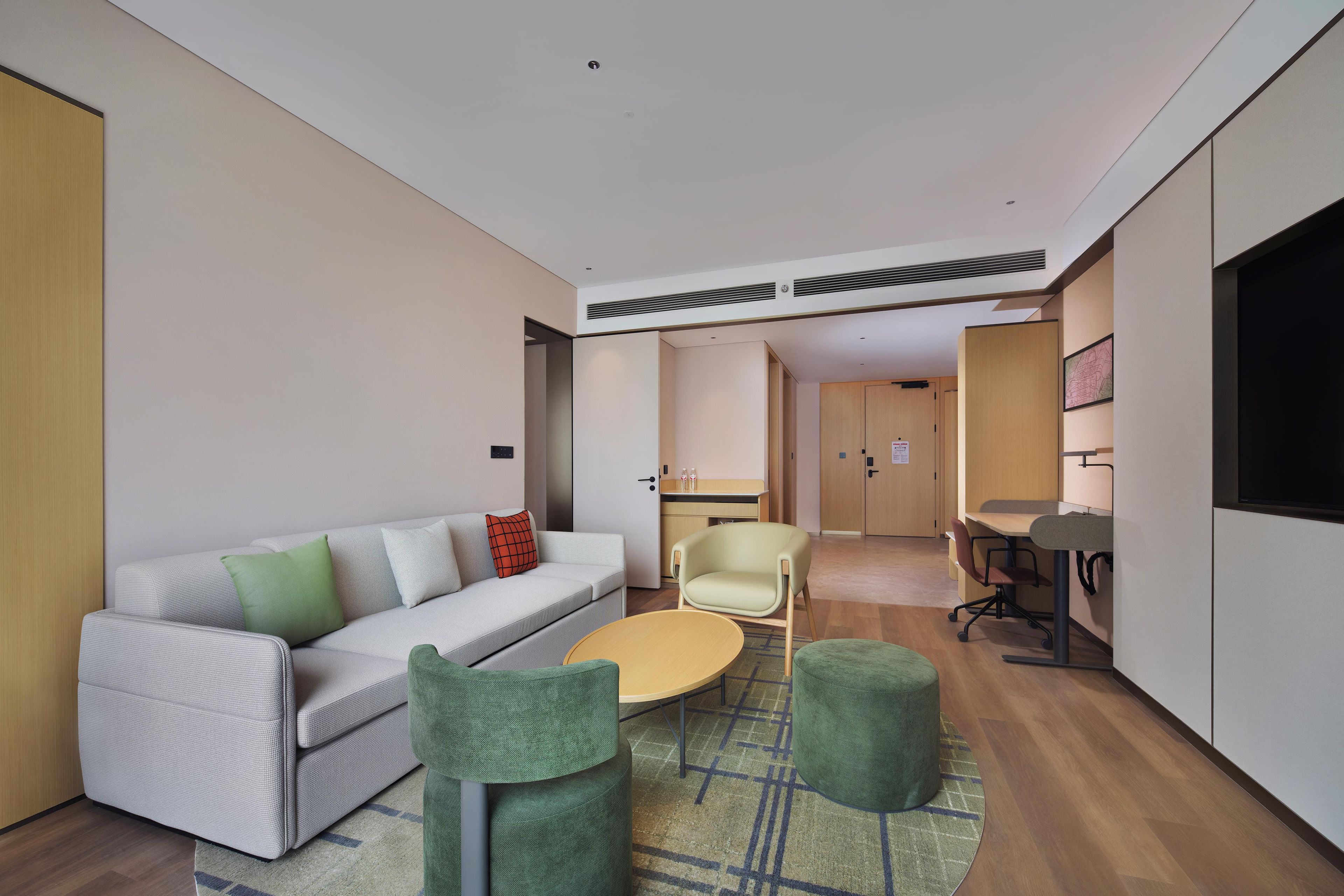 A modern living room with a sofa, chairs, a coffee table, and a dining area with a table and chairs.