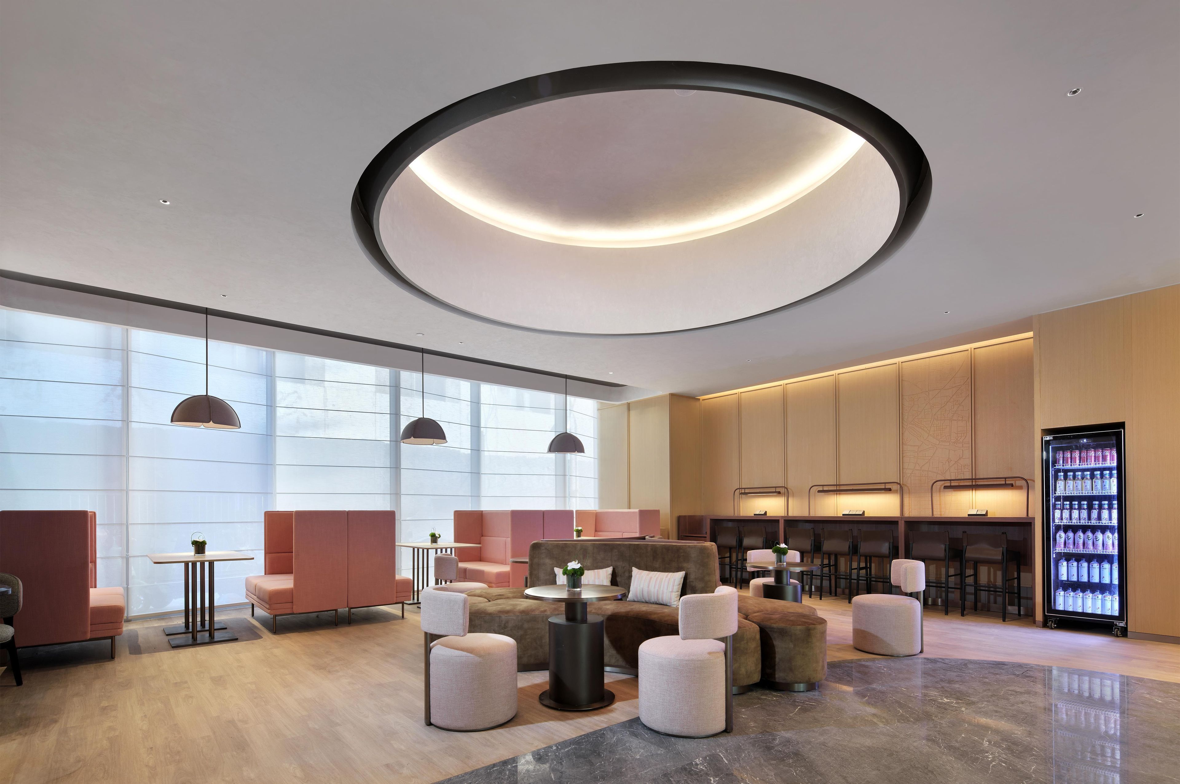 A modern lounge area with seating, a coffee machine, and a beverage dispenser.