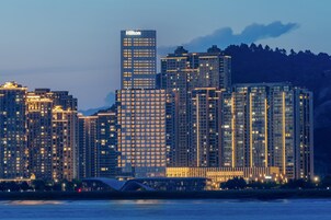 Un hotel moderno de gran altura con ventanas iluminadas y un llamativo letrero de Hilton.