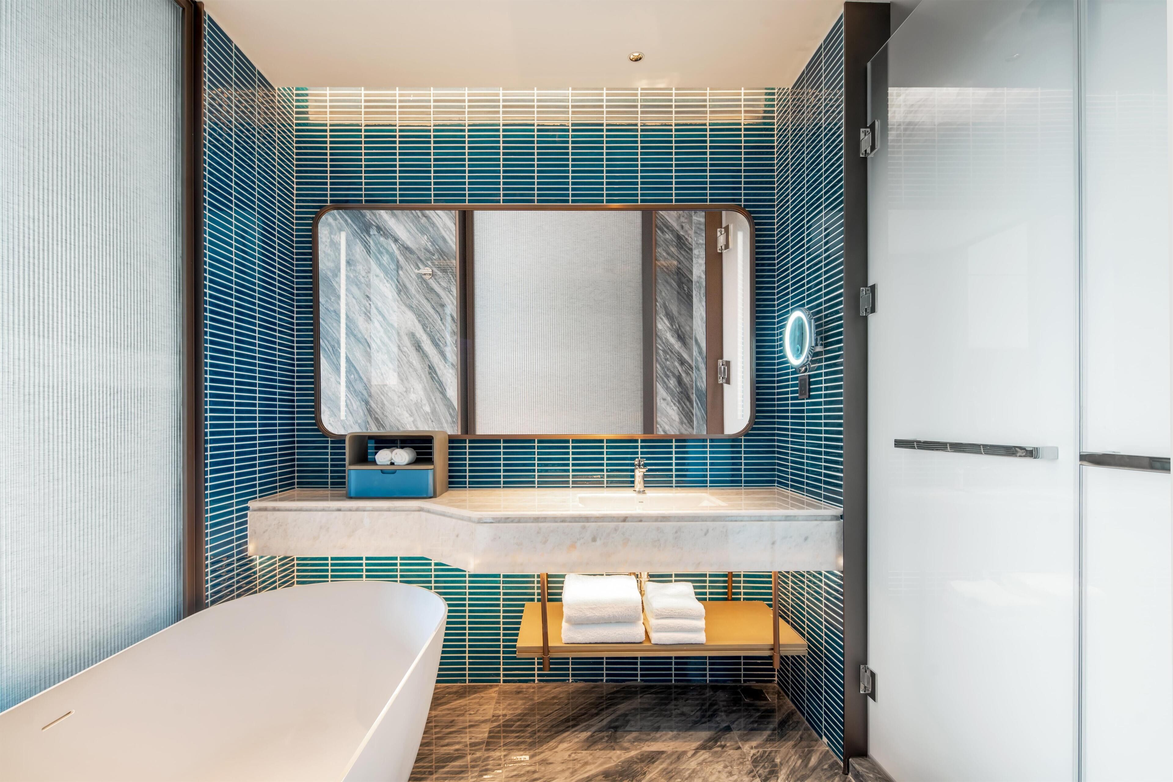 Un baño moderno con bañera, tocador con espejo y zona de ducha.