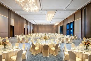 A large conference room with round tables, white chairs, and chandeliers. - Hilton Wenzhou (Wenzhou)