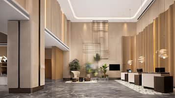 Um lobby moderno com balcão de recepção, área de estar e uma grande planta.