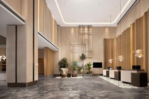 A modern lobby with a reception desk, seating area, and a large plant. - Hilton Garden Inn Zaozhuang Shizhong (Zaozhuang)