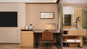 Une chambre d’hôtel équipée d’un bureau, d’une chaise et d’un petit coin cuisine.