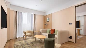 Una sala de estar moderna con un sofá, sillas, una mesa de centro y un televisor.