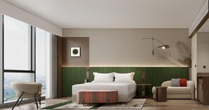 Et moderne hotelværelse med en stor seng, et siddeområde, udsigt over byen og en grøn accentvæg.