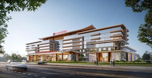 Et moderne hotel med flere etager, store vinduer og en markant indgang.
