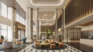 A modern lobby with a central seating area, large windows, and a patterned floor.
