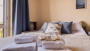 Une chambre d’hôtel avec un lit, des oreillers et des serviettes.