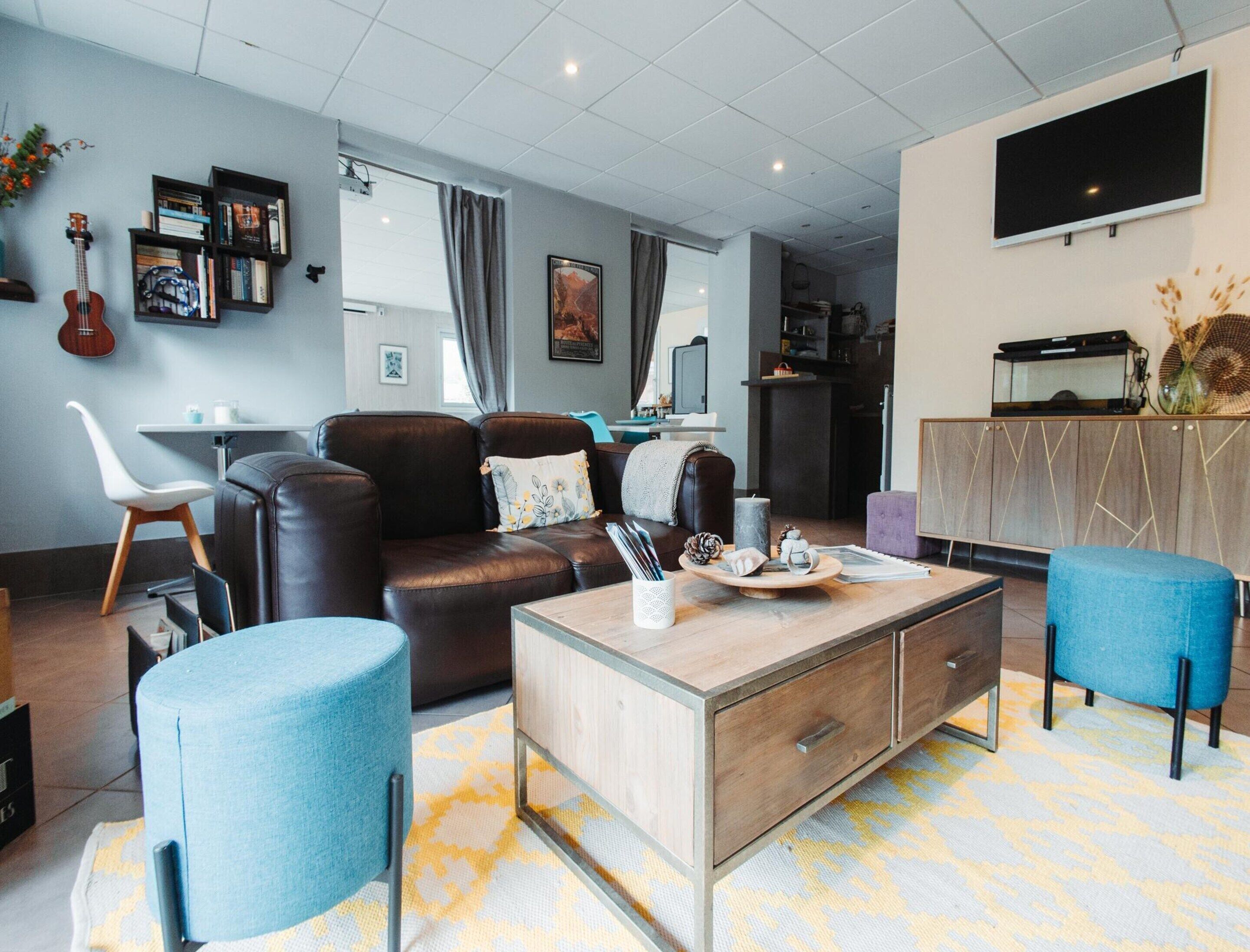 A modern living room with a leather sofa, a coffee table, and a TV.