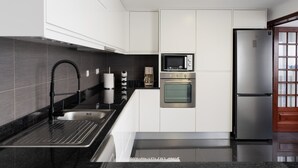 Eine moderne Küche mit Edelstahlkühlschrank, Backofen und Mikrowelle.