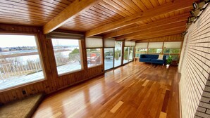 A spacious room with wooden floors, large windows, and a blue sofa.