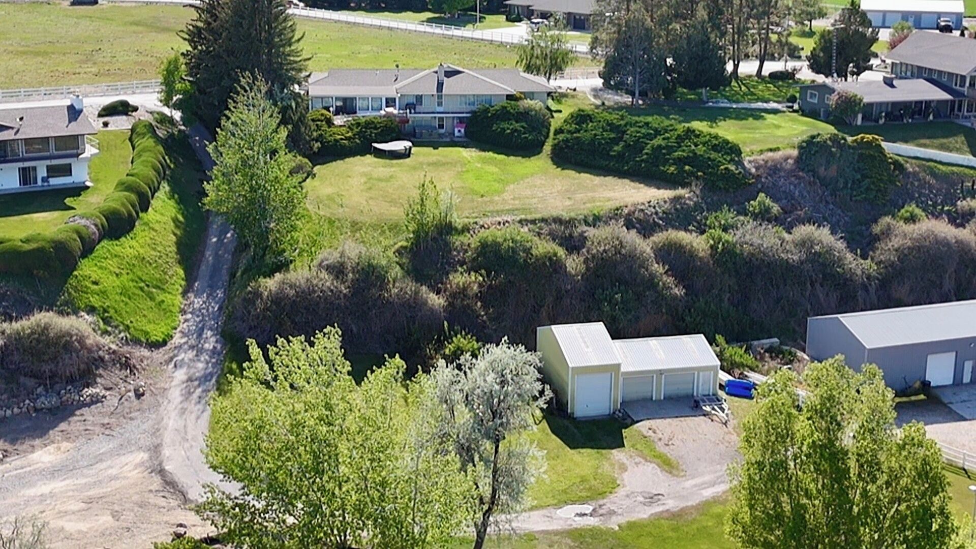 A residential area with houses, a small building, and a dirt path.