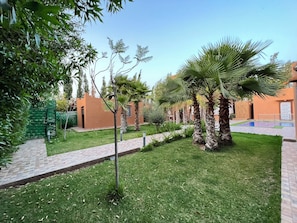 A courtyard with palm trees, a brick pathway, and a small pool. - Quiet villa away from the center, not overlooked (Douar Ârich)