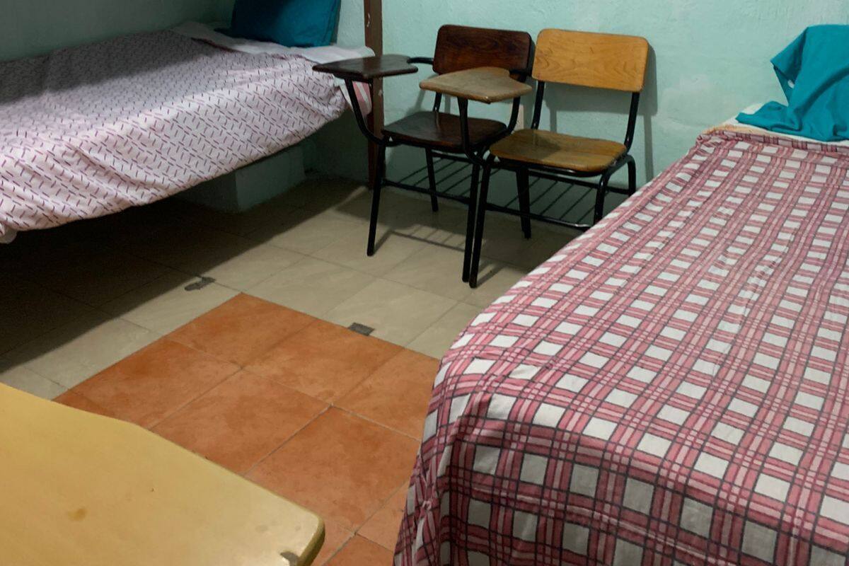 Ein Schlafsaalzimmer mit Etagenbetten, einem Schreibtisch und einem Stuhl.