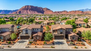 A residential area with houses featuring red-tiled roofs, surrounded by greenery and a mountain backdrop. - Paradise Village Resort 31/32 Retreat (Santa Clara)