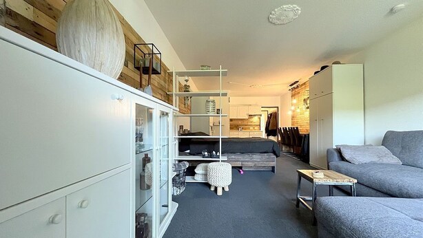 En moderne stue med sofa, sofabord og spiseplads.