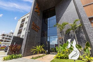 A modern building with a large glass entrance, a sign reading 'Beach House Delivery,' and a number '280' on the side. - Beach Haus #425 Quadruple in Bessa By Carpediem (João Pessoa)