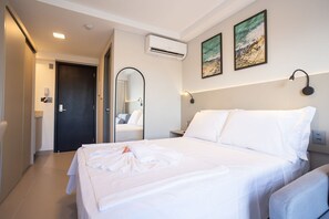 A hotel room with a bed, a mirror, an air conditioner, and artwork on the wall. - Beach Haus #425 Quadruple in Bessa By Carpediem (João Pessoa)