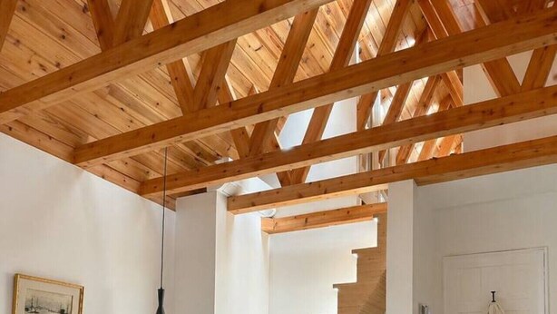 A bedroom with a wooden ceiling, a bed, a staircase, and a door with a robe hanging. - Stylish 2BR/2BA |Large Private Patio|Near Downtown (Vancouver)