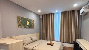 Un dormitorio moderno con una cama, un escritorio y un equipo de aire acondicionado.