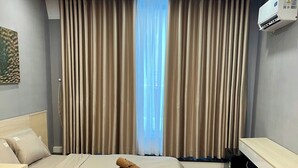 Una habitación de hotel con una cama, un escritorio, un radiador y un equipo de aire acondicionado.
