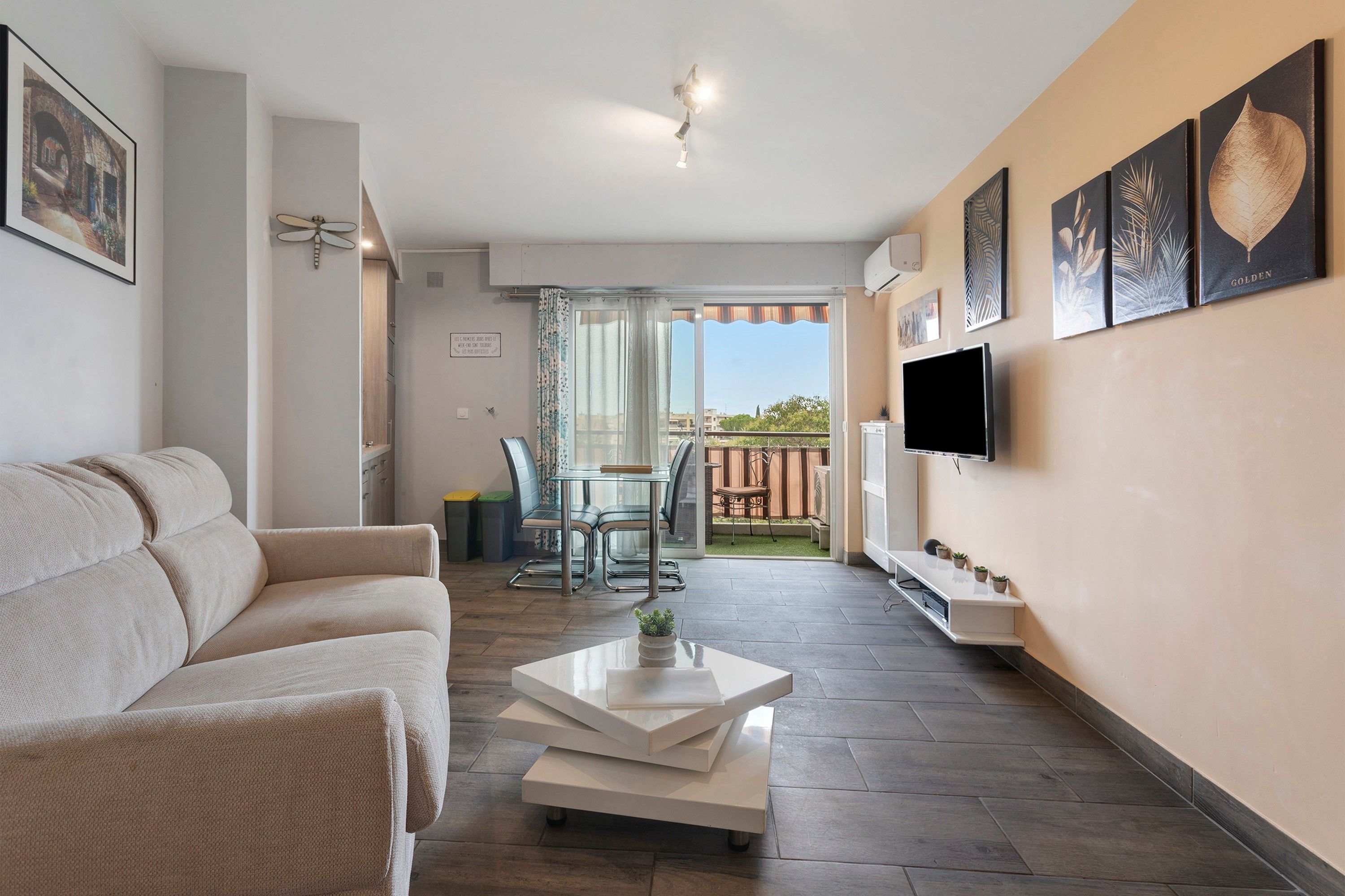 A modern living room with a sofa, coffee table, and artwork on the walls.