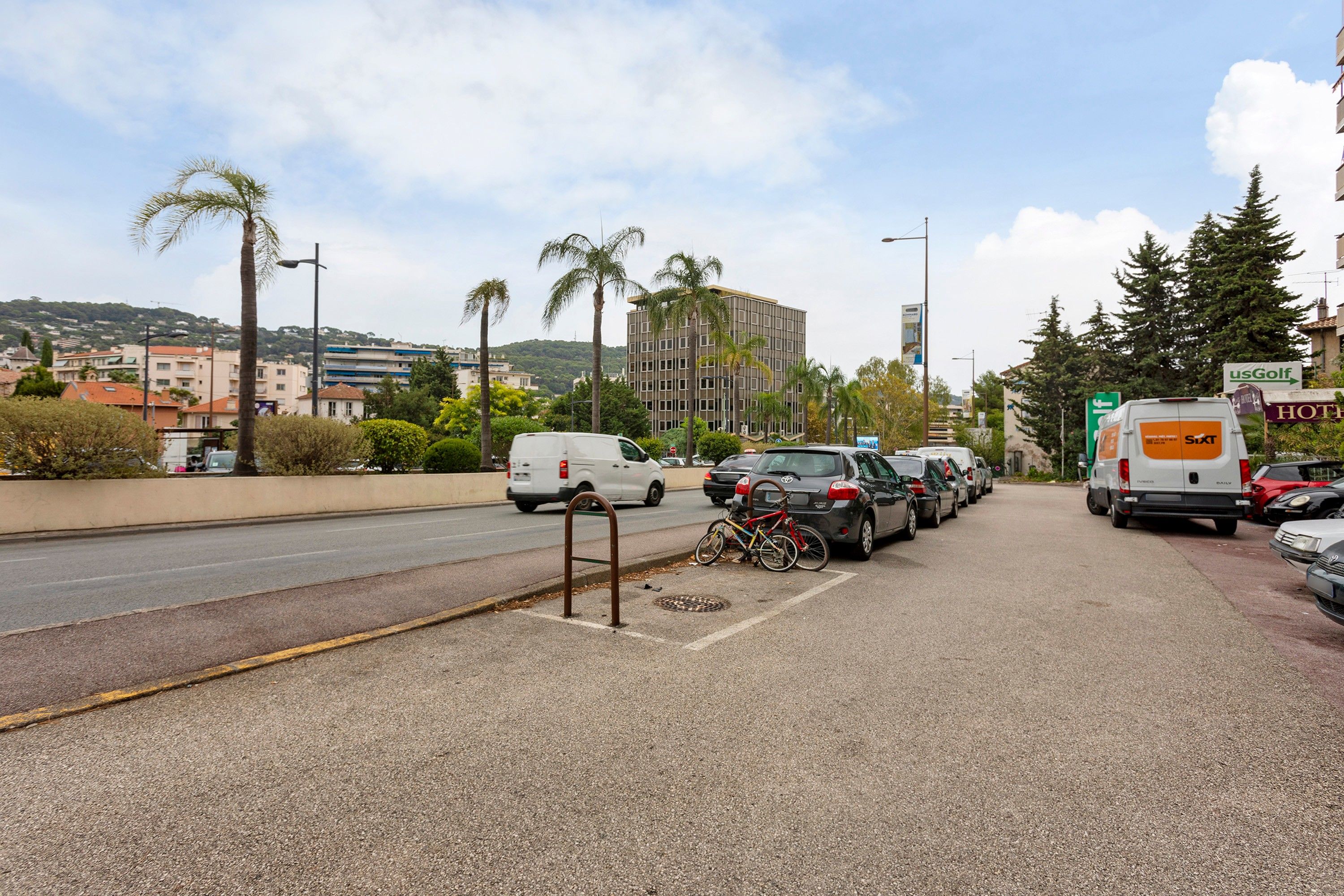 Eine Straße mit parkenden Autos und einem Fahrrad.