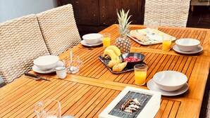A wooden dining table set with plates, cutlery, glasses, and a book. - The Elephant House in Vivonne (Vivonne)