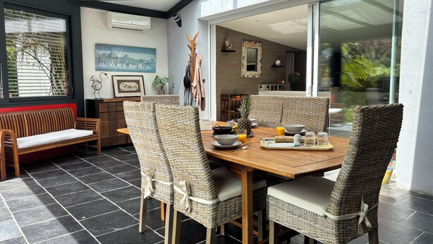 A dining area with a wooden table, wicker chairs, and a bench. - The Elephant House in Vivonne (Vivonne)