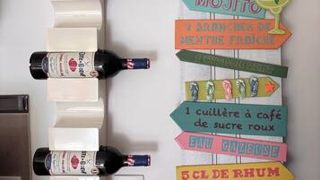 A wall with multiple bottles and a colorful sign with various items listed.