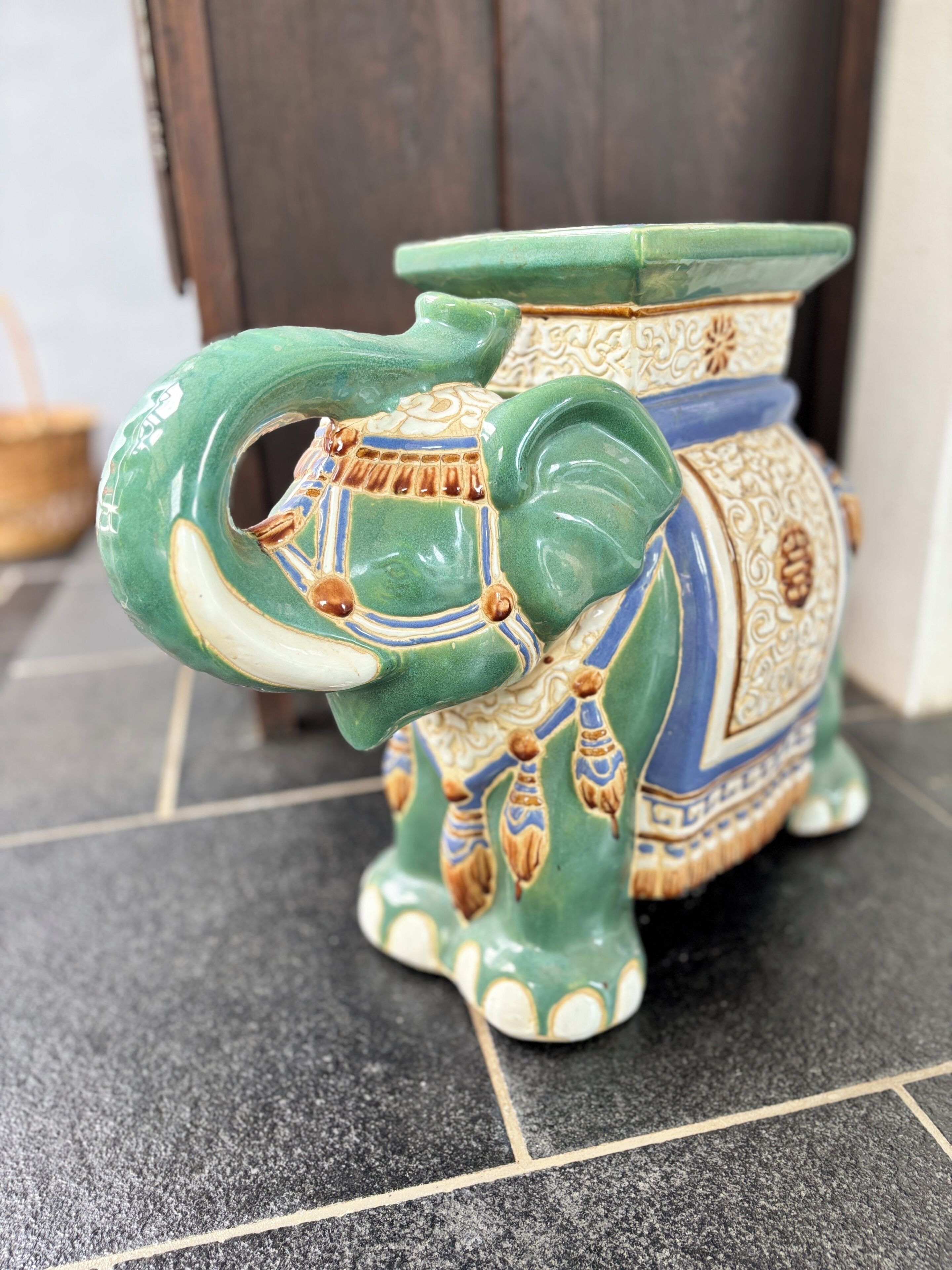A ceramic elephant-shaped vase with intricate patterns and a handle.