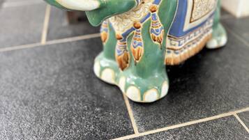 A ceramic elephant-shaped vase with intricate patterns and a handle.