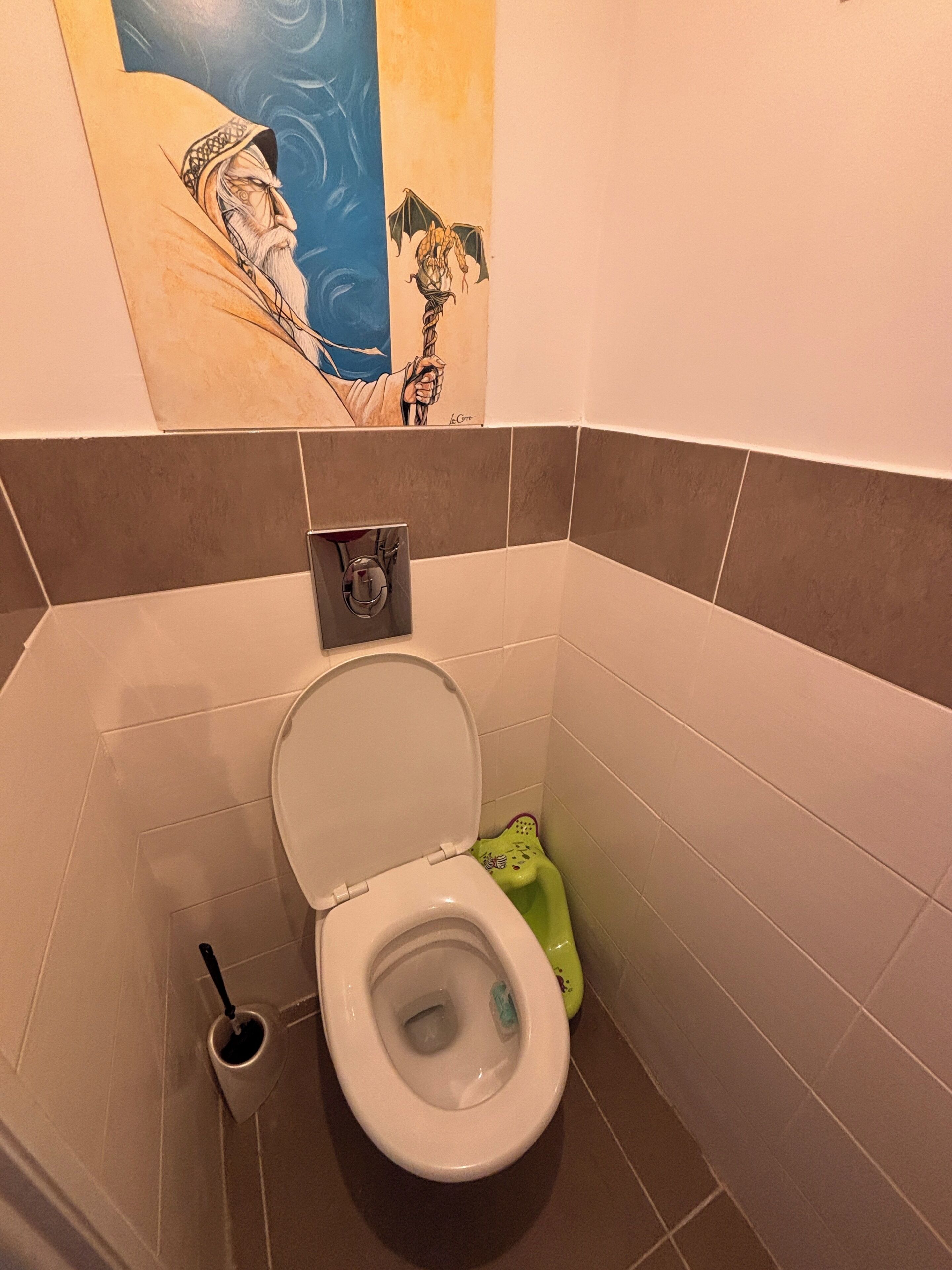 Een badkamer met een toilet, een bidet en een toiletrolhouder aan de muur.