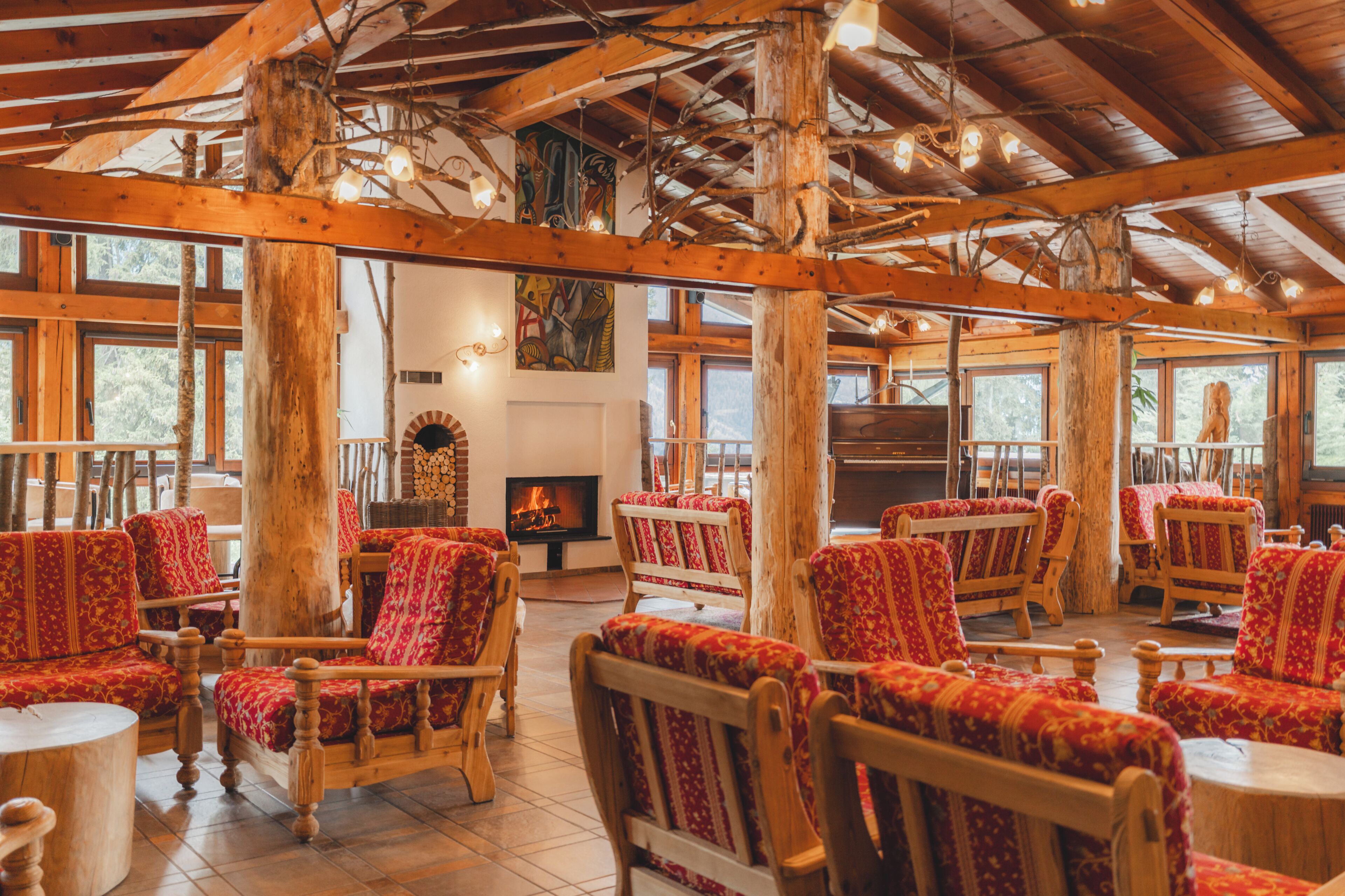 L’intérieur d’un chalet rustique, avec des meubles en bois, de grandes fenêtres et une cheminée.