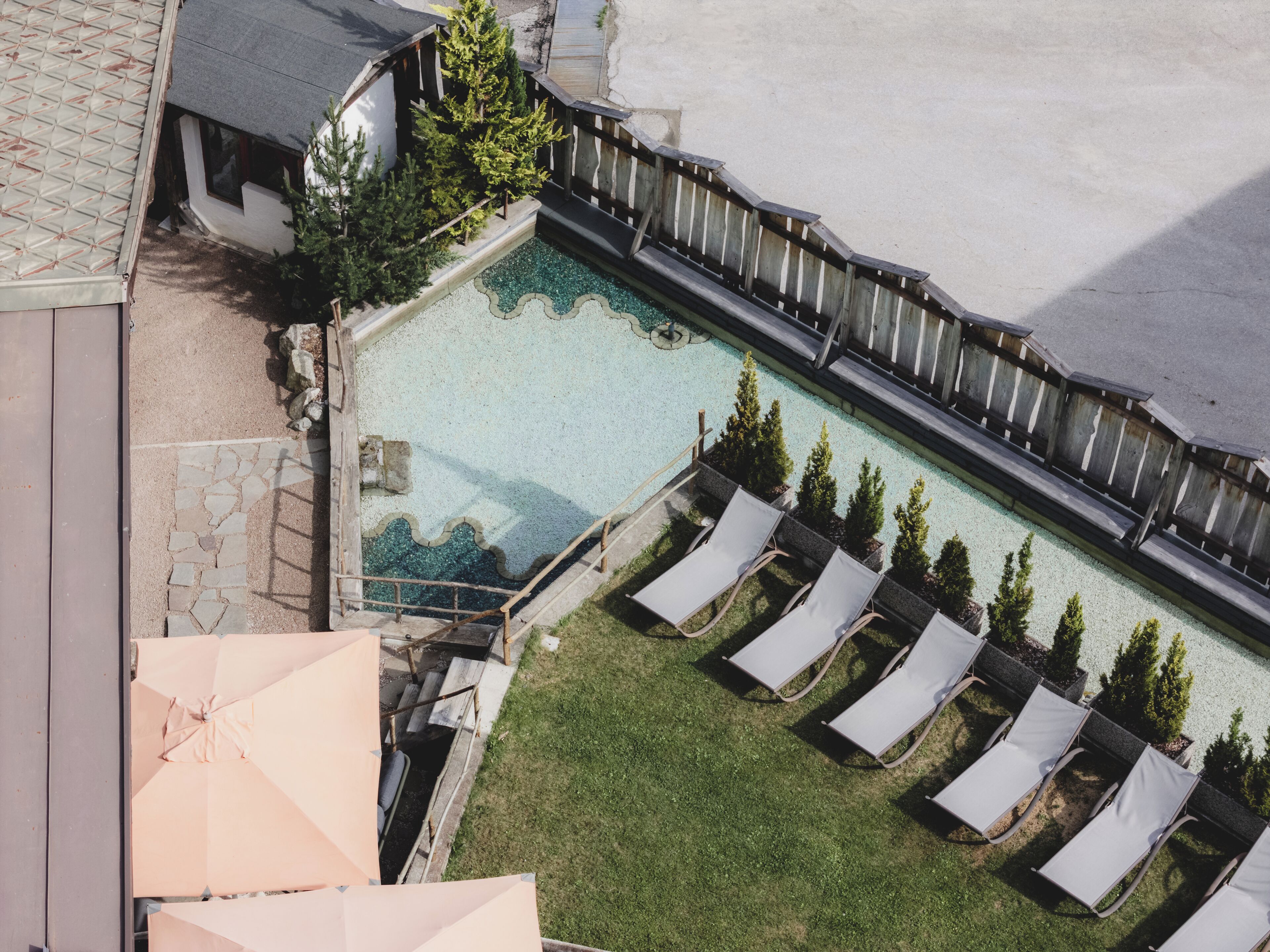 Une piscine sur le toit, dotée de chaises longues et d’une terrasse en bois.
