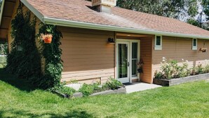 A single-story house with a front door, a small porch, and a well-maintained lawn.